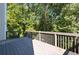 Spacious wooden deck with railings offering a private outdoor space surrounded by lush trees and natural scenery at 1814 Oak Branch Way, Loganville, GA 30052