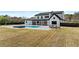 Expansive backyard featuring a modern farmhouse, pool and spa, outdoor seating, and a large grassy lawn at 2485 Brooks Rd, Dacula, GA 30019