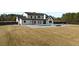 Large backyard showcasing a modern farmhouse, pool and spa, covered patio, outdoor seating, and a spacious lawn at 2485 Brooks Rd, Dacula, GA 30019