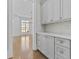 Charming butler's pantry featuring elegant gray cabinets, brass hardware, and decorative backsplash at 2485 Brooks Rd, Dacula, GA 30019