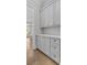 Charming butler's pantry featuring elegant gray cabinets, brass hardware, and decorative backsplash at 2485 Brooks Rd, Dacula, GA 30019
