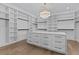 Spacious walk-in closet with custom shelving, drawers and ample storage, illuminated by stylish light at 2485 Brooks Rd, Dacula, GA 30019