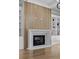 Striking fireplace with a light wood accent wall complemented by built-in cabinets and shelving, enhancing the room's warmth at 2485 Brooks Rd, Dacula, GA 30019