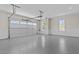 Spacious three-car garage featuring an epoxy floor and two windows with bead board walls at 2485 Brooks Rd, Dacula, GA 30019