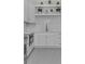 Bright kitchen featuring stainless steel appliances, custom cabinets, floating shelves, and patterned floors at 2485 Brooks Rd, Dacula, GA 30019