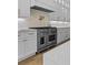 Close up of bright kitchen showcases a professional-grade range and custom cabinetry at 2485 Brooks Rd, Dacula, GA 30019