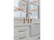 Up close shot of bright kitchen with farmhouse sink and white cabinetry featuring gold fixtures at 2485 Brooks Rd, Dacula, GA 30019