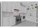 Gourmet kitchen features stainless steel appliances, custom white cabinets, patterned floor, and tile backsplash at 2485 Brooks Rd, Dacula, GA 30019