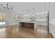 Bright, open kitchen features a large center island, stainless steel refrigerator, and abundant white cabinetry at 2485 Brooks Rd, Dacula, GA 30019