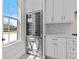 Bright kitchen area with stainless steel wine cooler, custom cabinets, patterned floors and large windows at 2485 Brooks Rd, Dacula, GA 30019