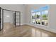 Open concept living room with light hardwood floors and black framed windows offering a scenic outdoor view at 2485 Brooks Rd, Dacula, GA 30019