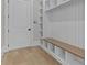 Bright mudroom with custom built-ins, a wooden bench, open shelving, and durable wood flooring at 2485 Brooks Rd, Dacula, GA 30019
