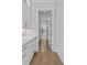 Bright walk-in pantry with custom white cabinets, brass hardware, hardwood floors, and access to the kitchen at 2485 Brooks Rd, Dacula, GA 30019