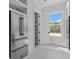 Kitchen pantry featuring stainless steel refrigerator, custom white shelves, and access to outdoor views at 2485 Brooks Rd, Dacula, GA 30019