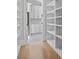Bright walk-in pantry with custom white shelves, hardwood floors, and access to another pantry with a fridge at 2485 Brooks Rd, Dacula, GA 30019