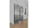 A gourmet kitchen features a stainless steel refrigerator with custom white cabinets and brass hardware at 2485 Brooks Rd, Dacula, GA 30019