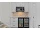 A beautifully designed wet bar featuring a beverage fridge, microwave, and pristine white cabinetry at 2485 Brooks Rd, Dacula, GA 30019