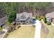 Aerial shot of home showing a long driveway, meticulous landscaping, a backyard pool, and surrounding woods at 304 Gilmer Ct, Canton, GA 30115