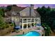 Twilight aerial view features a backyard oasis with a pool, deck, mature trees, and stylish outdoor furniture at 304 Gilmer Ct, Canton, GA 30115