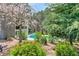 Backyard view of the pool area through the trees, with lush landscaping and mature trees at 304 Gilmer Ct, Canton, GA 30115