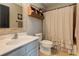 Charming bathroom featuring a vintage-style vanity, decorative shelf, and a classic shower curtain with ruffles at 304 Gilmer Ct, Canton, GA 30115