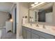 Bathroom featuring double sinks, gray cabinets, a large mirror and a view into the connected bedroom at 304 Gilmer Ct, Canton, GA 30115