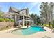 Exterior view of a beautiful home with a pool and multiple outdoor living spaces at 304 Gilmer Ct, Canton, GA 30115