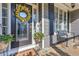 Close-up of a charming porch with a decorative wreath, bench, and potted flowers by the front door at 304 Gilmer Ct, Canton, GA 30115