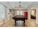 Charming game room features a pool table, wood floors, bar stools, a red refrigerator and backyard access at 304 Gilmer Ct, Canton, GA 30115