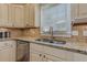 Bright kitchen area with stainless steel sink, granite counters, and traditional cabinetry with a window view at 304 Gilmer Ct, Canton, GA 30115