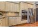 Kitchen area featuring stainless steel appliances, double ovens, and cream-colored cabinetry at 304 Gilmer Ct, Canton, GA 30115