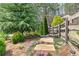 A stone path leads through landscaped gardens with a variety of plants, bushes and trees at 304 Gilmer Ct, Canton, GA 30115