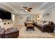 Bright living room features a ceiling fan, comfortable leather furniture, and unique decor at 304 Gilmer Ct, Canton, GA 30115