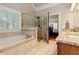 Serene main bathroom featuring a soaking tub, glass shower, and natural light from the window at 304 Gilmer Ct, Canton, GA 30115