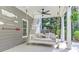 A covered patio is decorated with a hanging swing bed, paddles, and nautical decor at 304 Gilmer Ct, Canton, GA 30115
