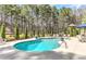 In-ground pool with a concrete surround and view of the wooded area providing backyard privacy at 304 Gilmer Ct, Canton, GA 30115