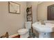 Charming powder room featuring stylish decor, a pedestal sink, and a decorative ladder shelf at 304 Gilmer Ct, Canton, GA 30115