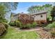 Multi-level backyard featuring a patio, green grass, stone steps, and mature trees at 1235 Saint Ives Ct, Suwanee, GA 30024