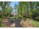 Lush backyard featuring mature trees, mulched areas, a rock drainage, a swing, and beautiful landscaping at 1235 Saint Ives Ct, Suwanee, GA 30024