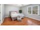 Bedroom featuring hardwood floors, neutral walls, and a bright window at 1235 Saint Ives Ct, Suwanee, GA 30024