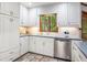 Bright kitchen with white cabinetry, stainless steel appliances, and a window with a wooded view at 1235 Saint Ives Ct, Suwanee, GA 30024