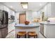 Bright kitchen features white cabinets, stainless steel appliances, an island, and tile flooring at 1235 Saint Ives Ct, Suwanee, GA 30024