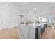 Bright and airy kitchen showcasing a large island, stainless steel sink, and adjacent dining area at 486 Broom Dr, Cumming, GA 30040
