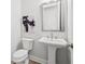 Stylish powder room with a pedestal sink, modern mirror, and neutral wall color at 486 Broom Dr, Cumming, GA 30040