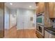 Hallway with hardwood floors and modern appliances adjacent to double doors and kitchen cabinets at 51 Muirfield Ct, Hiram, GA 30141
