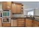 Kitchen with stainless steel dishwasher and double oven, granite counters, and wood cabinets at 51 Muirfield Ct, Hiram, GA 30141