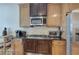 Kitchen featuring stainless steel microwave and cooktop set in wooden cabinets with black granite countertops at 51 Muirfield Ct, Hiram, GA 30141