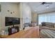 Cozy living room with a fireplace, hardwood floors, and lots of natural light at 51 Muirfield Ct, Hiram, GA 30141