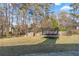 Large backyard featuring a trampoline, lawn and partially fenced perimeter at 704 Manor Ridge Dr, Loganville, GA 30052