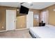 Carpeted bedroom with a ceiling fan and a large TV on the wall at 704 Manor Ridge Dr, Loganville, GA 30052
